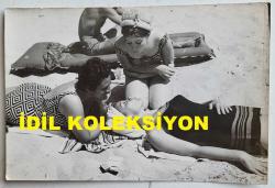 YEŞİLÇAM'IN YILDIZI HÜLYA KOÇYİĞİT'İN ORİJİNAL FOTOĞRAFI  - 18 x 12 cm EBADINDA - HÜLYA KOÇYİĞİT, ANNNESİ MELEK KOÇYİĞİT ve KARDEŞ NİLÜFER KOÇYİĞİT İLE KUMSALDA GÜNEŞLENİRKEN ÇEKİLMİŞ BİR AİLE FOTOĞRAFI