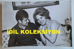 YEŞİLÇAM'IN YILDIZI HÜLYA KOÇYİĞİT'İN ORİJİNAL FOTOĞRAFI - 18 x 12 cm EBADINDA - HÜLYA KOÇYİĞİT, EŞİ SELİM SOYDAN'IN YANINDA KADRAJA GÜLÜMSERKEN ÇEKİLMİŞ BİR KARE (HÜNER ŞARMAN)