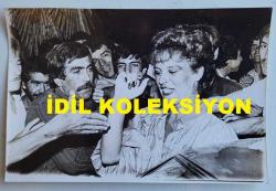 YEŞİLÇAM'IN YILDIZI HÜLYA KOÇYİĞİT'İN ORİJİNAL AJANS-BASIN FOTOĞRAFI - 18 x 12 cm EBADINDA - HÜLYA KOÇYİĞİT, İZMİR FUARI'NDE HAYRANLARININ ARASINDAYKEN ÇEKİLMİŞ BİR KARE. AĞUSTOS 1983