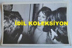 YEŞİLÇAM'IN YILDIZI HÜLYA KOÇYİĞİT'İN ORİJİNAL AJANS-BASIN FOTOĞRAFI - 18 x 12 cm EBADINDA - HÜLYA KOÇYİĞİT, KAPI GİRİŞİNDE KONUŞURKEN ÇEKİLMİŞ BİR KARE