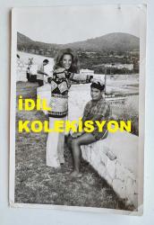 YEŞİLÇAM'IN YILDIZI HÜLYA KOÇYİĞİT'İN ORİJİNAL AJANS-BASIN FOTOĞRAFI - 18 x 12 cm EBADINDA - HÜLYA KOÇYİĞİT, EVLAT EDİNDİĞİ OSMAN'IN YANINDA GÜLÜMSERKEN ÇEKİLMİŞ BİR KARE