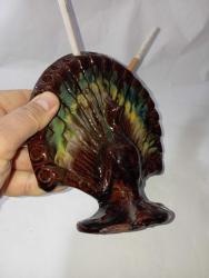 tavus kuşu formunda tasarlanmış antika bir Çanakkale işi sigaralık. 20. yüzyıl başına ait, pişmiş topraktan üretilmiş sırlı bir koleksiyon parçasıdır. 20 sigara kapasitesine sahiptir. Koyu kahverengi, yeşil ve sarı renkli sırlar kullanılarak el işçiliği ile yapılmıştır.