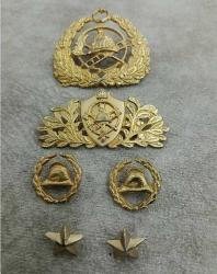 1940/1950 lerden eski itfaiyeci kokartları, rozetleri ve brövelerinden oluşan bir koleksiyon grubu.  İçerik: İtfaiyeci kaskı ve merdiven temalı kokartlar, rozetler ve apolet yıldızları.   Kullanım: Bu tür objeler tarihsel olarak üniformalarda mesleki bröve veya rozet olarak kullanılmıştır.   Koleksiyon Değeri: Genellikle antika veya hobi amaçlı koleksiyoncular için değer taşırlar. 