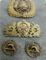 1940/1950 lerden eski itfaiyeci kokartları, rozetleri ve brövelerinden oluşan bir koleksiyon grubu.  İçerik: İtfaiyeci kaskı ve merdiven temalı kokartlar, rozetler ve apolet yıldızları.   Kullanım: Bu tür objeler tarihsel olarak üniformalarda mesleki bröve veya rozet olarak kullanılmıştır.   Koleksiyon Değeri: Genellikle antika veya hobi amaçlı koleksiyoncular için değer taşırlar. 