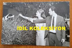 YEŞİLÇAM'IN YILDIZI HÜLYA KOÇYİĞİT'İN ORİJİNAL FOTOĞRAFI  - 18 x 12 cm EBADINDA - HÜLYA KOÇYİĞİT ve SELİM SOYDAN, BAHÇE KENARINDAKİ KÖPEĞİ SEVERLERKEN ÇEKİLMİŞ BİR KARE