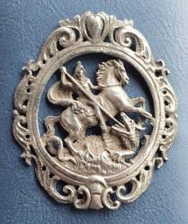 Fransa, Antika Katolik Dini Madalyon. Aziz Lyddli George'un Bir Ejderhayla Verdiği Şiddetli Savaşı Tasvir Eden Zarif Bir Kolye/Broş Ucu; Bu da Hristiyan İnancının Şeytan Üzerindeki Zaferinin Veya Daha Geniş Anlamda İyiliğin Kötülüğe Karşı Zaferinin Alegorisidir. 19. Yüzyıl Başlarına Ait. İnce İşçilikle Üretilmiş, Gümüş Kaplama Metal-Kalay. Patinalı. (55×65 mm) Nadir.