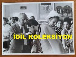 YEŞİLÇAM'IN YILDIZI HÜLYA KOÇYİĞİT'İN ORİJİNAL BÜYÜK BOY 2'Lİ FOTOĞRAF SETİ - 24 x 18 cm EBADINDA - HÜLYA KOÇYİĞİT ve EŞİ SELİM SOYDAN, HAVA LİMANINDAYKEN SELİM SOYDAN'IN BABASI MUSTAFA ARİF SOYDAN'IN ELİNİ ÖPÜP VEDALAŞIRLARKEN ÇEKİLMİŞ 2 FARKLI KARE