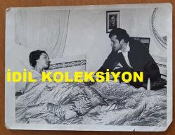 YEŞİLÇAM'IN YILDIZI HÜLYA KOÇYİĞİT'İN ORİJİNAL BÜYÜK BOY FOTOĞRAFI - 24 x 18 cm EBADINDA - HÜLYA KOÇYİĞİT, HASTA YATAĞINDA İSTİRAHAT EDERKEN KENDİSİNE TESELLİ VEREN EŞİ SELİM SOYDAN'LA AYNI KAREDEYKEN ÇEKİLMİŞ BİR FOTOĞRAF