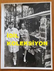 YEŞİLÇAM'IN YILDIZI HÜLYA KOÇYİĞİT'İN ORİJİNAL BÜYÜK BOY 2'Lİ FOTOĞRAF SETİ - 24 x 18 cm EBADINDA - HÜLYA KOÇYİĞİT ve EŞİ SELİM SOYDAN, AVRUPA SEYAHATLERİ SIRASINDA MAĞAZALARIN YER ALDIĞI CADDELERDE YÜRÜRLERKEN YAĞMURLU BİR HAVADA ÇEKİLMİŞ 2 ÖZEL KARE