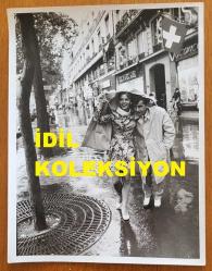 YEŞİLÇAM'IN YILDIZI HÜLYA KOÇYİĞİT'İN ORİJİNAL BÜYÜK BOY 2'Lİ FOTOĞRAF SETİ - 24 x 18 cm EBADINDA - HÜLYA KOÇYİĞİT ve EŞİ SELİM SOYDAN, AVRUPA SEYAHATLERİ SIRASINDA MAĞAZALARIN YER ALDIĞI CADDELERDE YÜRÜRLERKEN YAĞMURLU BİR HAVADA ÇEKİLMİŞ 2 ÖZEL KARE