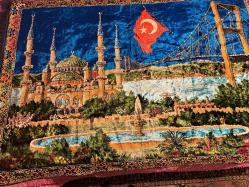 İstanbul Temalı Kadife Duvar Halısı 170x115 cm Üzerinde Sultanahmet Camii, Boğaz Köprüsü ve Türk Bayrağı işlemeleri bulunan çok şık bir dekoratif halıdır. Canlı renklere sahip, yumuşak kadife dokuludur. Işığa göre renk değiştiren parlak bir yapısı vardır. Temiz kullanılmış, yırtığı veya söküğü yoktur.