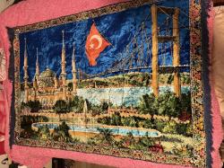 İstanbul Temalı Kadife Duvar Halısı 170x115 cm Üzerinde Sultanahmet Camii, Boğaz Köprüsü ve Türk Bayrağı işlemeleri bulunan çok şık bir dekoratif halıdır. Canlı renklere sahip, yumuşak kadife dokuludur. Işığa göre renk değiştiren parlak bir yapısı vardır. Temiz kullanılmış, yırtığı veya söküğü yoktur.