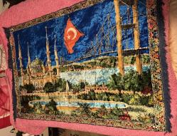 İstanbul Temalı Kadife Duvar Halısı 170x115 cm Üzerinde Sultanahmet Camii, Boğaz Köprüsü ve Türk Bayrağı işlemeleri bulunan çok şık bir dekoratif halıdır. Canlı renklere sahip, yumuşak kadife dokuludur. Işığa göre renk değiştiren parlak bir yapısı vardır. Temiz kullanılmış, yırtığı veya söküğü yoktur.