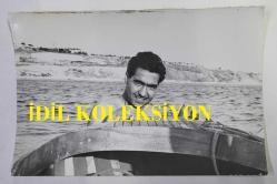 NURİ SESİGÜZEL'İN ORİJİNAL 2'Lİ FOTOĞRAF SETİ  - 18 x 12 cm EBADINDA  - NURİ SESİGÜZEL, DENİZDE YÜZERKEN ve SANDALA TUTUNUP KADRAJA POZ VERİRKEN ÇEKİLMİŞ 2 FARKLI KARE