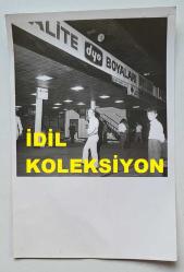 ŞANTÖZ ANNA MARIA'NIN ORİJİNAL 2'Lİ FOTOĞRAF SETİ - 18 x 12 cm EBADINDA - ANNA MARIA, TROMPETİST EŞİ TUNCER ÖZCAN'LA BİRLİKTE KADIKÖY İSKELESİNDEYKEN ÇEKİLMİŞ 2 FARKLI KARE (İSKELE ÜZERİNDE DYO BOYALARI REKLAM TABELASI)