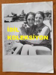 BİRSEN ARMAĞAN'IN ORİJİNAL BÜYÜK BOY AJANS-BASIN FOTOĞRAFI - 24 x 18 cm EBADINDA - BİRSEN ARMAĞAN, SELDA ALKOR'LA KUMSALDA BİRBİRLERİNE SARILIP HATIRA POZU VERİRLERKEN ÇEKİLMİŞ BİR KARE