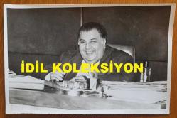 SANAYİCİ, İŞ ADAMI ve TÜSİAD ESKİ BAŞKANI ALİ KOÇMAN'IN ORİJİNAL FOTOĞRAFI - 18 x 12 cm EBADINDA - ALİ KOÇMAN, ÇALIŞMA MASASINDA GÜLÜMSERKEN ÇEKİLMİŞ BİR KARE