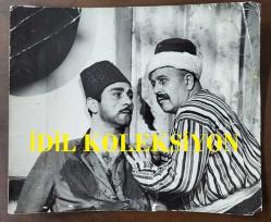 VAHİ ÖZ'ÜN ORİJİNAL BÜYÜK BOY FOTOĞRAFI - 21,5 x 18 cm EBADINDA  - VAHİ ÖZ ''KOCATEPE'NİN ÜÇ SÜVARİSİ (1964)'' İSİMLİ YEŞİLÇAM FİLMİNDE YILDIRIM GENCER'LE AYNI KAREDE (BANTLA ONARILMIŞ YIRTILMALARA ve KIRILMALAR VARDIR)