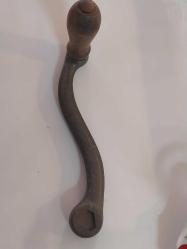 El Krankı, Bu görseldeki nesne, eski dikiş makineleri, fonograflar veya diğer mekanik cihazlar için kullanılan antik bir el krankıdır.  Malzeme: Genellikle dökme demir veya metalden üretilmiş sağlam bir gövdeye sahiptir.  Özellik: Döner bir ahşap veya plastik tutamağı bulunur.  İşlev: Döndürme hareketini mekanik enerjiye çevirerek makineyi manuel olarak çalıştırmak için kullanılır.  Kullanım Alanı: Vintage dikiş makineleri, müzik kutuları veya eski el aletleri için yedek parça veya koleksiyon objesi olarak değerlidir.