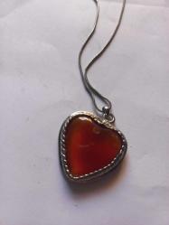 Gümüş renginde  ortasında akik taş bulunan  2 cm boyutunda kalp formunda kolye