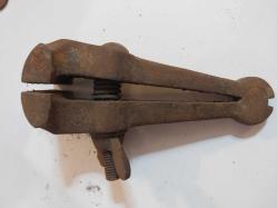 El Mengenesi. Osmanlı dönemine ait el yapımı bir el mengenesi (hand vice) koleksiyon parçasıdır.  Tarihi Değer: Genellikle dövme demirden üretilen bu tür aletler, antika ve koleksiyon değeri taşır.  Kullanım Alanı: Küçük parçaları tutmak, sıkıştırmak veya zımparalama/eğeleme işlemleri sırasında sabit tutmak için kullanılırdı.  Özellikleri: Görseldeki örnekte, parçayı sabitlemek için kullanılan klasik bir vida mekanizması ve yay bulunmaktadır.  Kullanım Amaçları: Takı yapımı, saat tamiri veya küçük metal parçaların işlenmesi gibi hassas işlerde yaygındı.