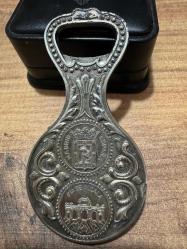 Vintage Gümüş Kaplama Madrid Temalı Şişe Açacağı – Koleksiyonluk  Gümüş kaplama, ağır ve tok bir yapıya sahiptir. Çift taraflı Madrid temalı kabartma işçilik. Bir yüzde: Ünlü Kibele Çeşmesi (Cibeles). Diğer yüzde: Alcalá Kapısı (Puerta de Alcalá) ve Madrid şehir arması.