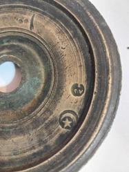 Osmanlı Dönemi Damgalı 100 Dirhem Ağırlık. Osmanlı dönemine ait bronz veya pirinç bir dirhem ağırlığıdır.  Kullanım Amacı: Bu ağırlıklar, çarşı ve pazarlarda terazi ile malların tartılması için kullanılırdı.  Özellikleri: Genellikle disk şeklinde olup, merkezinde bir delik bulunur.  Damgalar: Üzerinde Osmanlı damgaları (tuğra, ay-yıldız gibi) bulunur ve bu damgalar ağırlığın doğruluğunu gösterir.  Tarihi Değer: Osmanlı ticaret ve ekonomi tarihinin önemli parçalarıdır ve günümüzde koleksiyon değeri taşırlar.