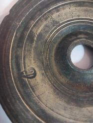 Osmanlı Dönemi Damgalı 100 Dirhem Ağırlık. Osmanlı dönemine ait bronz veya pirinç bir dirhem ağırlığıdır.  Kullanım Amacı: Bu ağırlıklar, çarşı ve pazarlarda terazi ile malların tartılması için kullanılırdı.  Özellikleri: Genellikle disk şeklinde olup, merkezinde bir delik bulunur.  Damgalar: Üzerinde Osmanlı damgaları (tuğra, ay-yıldız gibi) bulunur ve bu damgalar ağırlığın doğruluğunu gösterir.  Tarihi Değer: Osmanlı ticaret ve ekonomi tarihinin önemli parçalarıdır ve günümüzde koleksiyon değeri taşırlar.