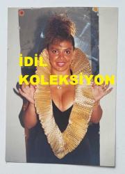 SES SANATÇISI SERPİL BENAY'IN ORİJİNAL FOTOĞRAFI  - 12,5 x 9 cm EBADINDA - SERPİL BENAY, DEKOLTE ELBİSESİYLE KADRAJA GÜLÜMSEYEREK POZ VERİRKEN ÇEKİLMİŞ NET KALİTEDE BİR FOTOĞRAF. 14 AĞUSTOS 1989