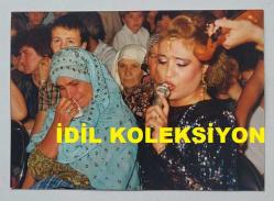 SES SANATÇISI SERPİL BENAY'IN ORİJİNAL FOTOĞRAFI  - 12,5 x 9 cm EBADINDA - SERPİL BENAY, AĞLAYAN BİR ANNEİN YANINDA ŞARKI OKURKEN ÇEKİLMİŞ NET KALİTEDE BİR FOTOĞRAF. 7 AĞUSTOS 1989