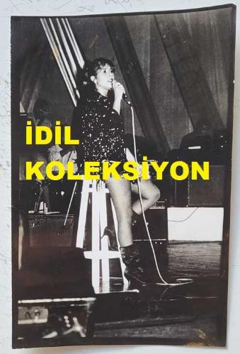 ŞARKICI ve SÖZ YAZARI NİLÜFER'İN ORİJİNAL AJANS-BASIN FOTOĞRAFI (NİLÜFER YUMLU) - 18 x 12 cm EBADINDA - NİLÜFER, SAHNEDE OTURARAK ŞARKI OKURKEN ÇEKİLMİŞ BİR KARE. 14 EKİM 1984