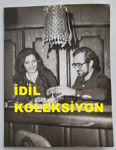 ŞANTÖZ AYLA AKINCI'NIN ORİJİNAL FOTOĞRAFI - 19 x 14,5 cm EBADINDA - AYLA AKINCI,  EŞİ TUNCAY ERENAY İLE AÇMIŞ OLDUĞU İSTANBUL SANAT DERNEĞİ'NİN AÇILIŞINDA KONUKLAR İÇİN KOKTEYL HAZIRLARKEN ÇEKİLMİŞ BİR KARE