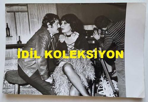 TANJU GÜRSU'NUN ORİJİNAL FOTOĞRAFI - 18 x 12 cm EBADINDA - TANJU GÜRSU ve SEVDA FERDAĞ BİR YEŞİLÇAM FİLMİNDE AYNI SAHNEDELERKEN ÇEKİLMİŞ NET KALİTEDE BİR FOTOĞRAF