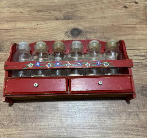 Vintage Ahşap Baharatlık Takımı El boyaması çiçek motifli, kırmızı lake ahşap stand ve   6 adet cam baharat şişesi ve alt kısımda 2 adet fonksiyonel küçük çekmece mevcuttur.