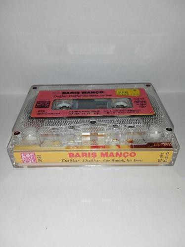Kaset Barış Manço dağlar dağlar, işte hendek işte deve. Orijinal. 1986 Harika kasetçilik dönem Kağıt Baskı. A6 dağlar dağlar şarkısında 2 saniye kayıp var. Kartonet tertemiz  Kaset gövdesi üzerindeki etiket farklılığının nedeni; özellikle 80'li ve 90'lı yıllarda kaset firmaları tarafından satmayan kağıt baskı kasetlerin üzerine yeni kağıt yapıştırılıp piyasaya sürülürdü. Bu durum tamamen o dönemin malzeme değerlendirme ve stok eritme yöntemlerinden kaynaklanan, kasetin orijinalliğini ve dönem ruhunu bozmayan bir detaydır. Koleksiyoncular için farklı bir örnektir.