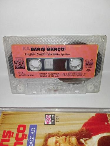 Kaset Barış Manço dağlar dağlar, işte hendek işte deve. Orijinal. 1986 Harika kasetçilik dönem Kağıt Baskı. A6 dağlar dağlar şarkısında 2 saniye kayıp var. Kartonet tertemiz  Kaset gövdesi üzerindeki etiket farklılığının nedeni; özellikle 80'li ve 90'lı yıllarda kaset firmaları tarafından satmayan kağıt baskı kasetlerin üzerine yeni kağıt yapıştırılıp piyasaya sürülürdü. Bu durum tamamen o dönemin malzeme değerlendirme ve stok eritme yöntemlerinden kaynaklanan, kasetin orijinalliğini ve dönem ruhunu bozmayan bir detaydır. Koleksiyoncular için farklı bir örnektir.
