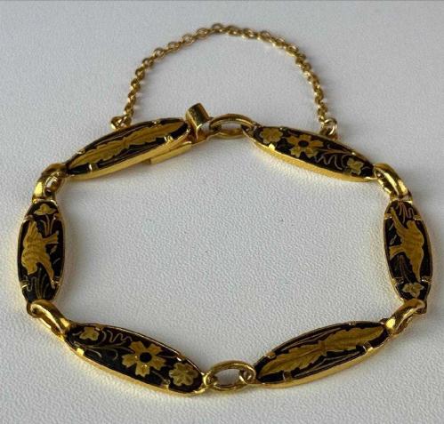 TOLEDO BİLEKLİK,  İspanyol Toledo - Kuş ve Çiçek Motifli Altın Kakma Damascene El İşçilikli - Vintage Bileklik Mağazamızda sizlerle buluşan bu detaylı bileklik, geleneksel Damascene (Şam işi) metal süsleme sanatının karakteristik özelliklerini yansıtıyor. Siyah zemin üzerine altın rengi işlemelerle bezenmiş bu takı, üzerindeki kuş ve çiçek motifleriyle vintage obje meraklılarının dikkatini çekiyor. Kendi döneminin el işçiliği geleneğini günümüze taşıyan bu tasarım, koleksiyonlar için kültürel bir değer taşıyor. Geleneksel motifleri üzerinde barındıran bu aksesuara koleksiyonunuzda yer açmalısınız..