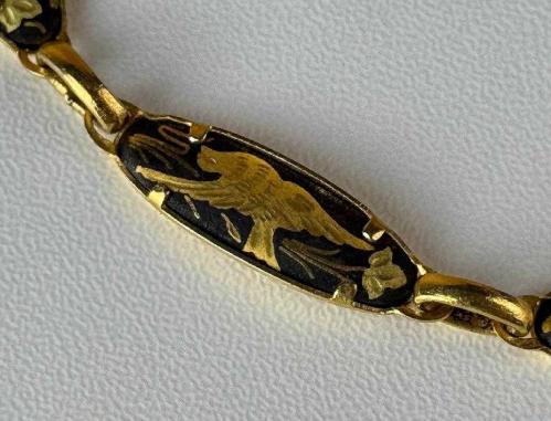 TOLEDO BİLEKLİK,  İspanyol Toledo - Kuş ve Çiçek Motifli Altın Kakma Damascene El İşçilikli - Vintage Bileklik Mağazamızda sizlerle buluşan bu detaylı bileklik, geleneksel Damascene (Şam işi) metal süsleme sanatının karakteristik özelliklerini yansıtıyor. Siyah zemin üzerine altın rengi işlemelerle bezenmiş bu takı, üzerindeki kuş ve çiçek motifleriyle vintage obje meraklılarının dikkatini çekiyor. Kendi döneminin el işçiliği geleneğini günümüze taşıyan bu tasarım, koleksiyonlar için kültürel bir değer taşıyor. Geleneksel motifleri üzerinde barındıran bu aksesuara koleksiyonunuzda yer açmalısınız..
