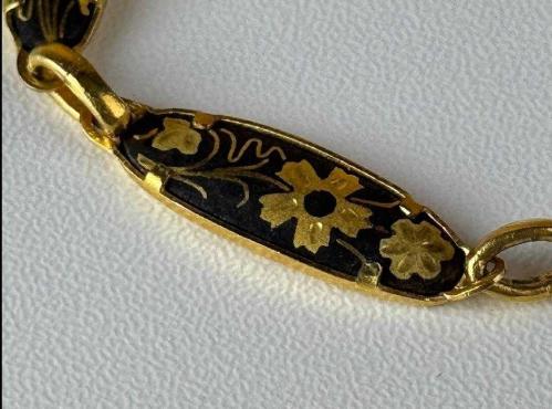 TOLEDO BİLEKLİK,  İspanyol Toledo - Kuş ve Çiçek Motifli Altın Kakma Damascene El İşçilikli - Vintage Bileklik Mağazamızda sizlerle buluşan bu detaylı bileklik, geleneksel Damascene (Şam işi) metal süsleme sanatının karakteristik özelliklerini yansıtıyor. Siyah zemin üzerine altın rengi işlemelerle bezenmiş bu takı, üzerindeki kuş ve çiçek motifleriyle vintage obje meraklılarının dikkatini çekiyor. Kendi döneminin el işçiliği geleneğini günümüze taşıyan bu tasarım, koleksiyonlar için kültürel bir değer taşıyor. Geleneksel motifleri üzerinde barındıran bu aksesuara koleksiyonunuzda yer açmalısınız..