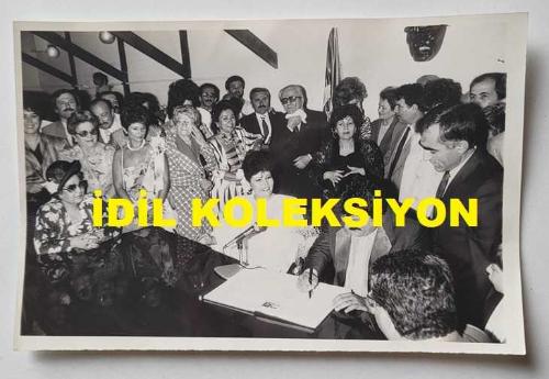 OSMAN YAĞMURDERELİ'NİN ORİJİNAL AJANS-BASIN FOTOĞRAFI - 18 x 12 cm EBADINDA - OSMAN YAĞMURDERELİ, ESİN ATASOY İLE EVLENİRKEN NİKAH TÖRENİNDE İMZA ATTIĞI SIRADA ÇEKİLMİŞ BİR KARE. 1986