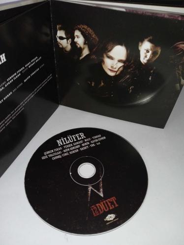 Cd Nilüfer 12 Düet Albümü. Nilüfer'in Rock düetlerinden oluşan albümüdür. Dinlemeyi etkilemeyen yoğun çizikler var. Baştan sona dinlendi sorunsuz çalışıyor.  Hayko Cepkin, Şebnem ferah, yüksek sadakat, malt, Teoman, gece yolcuları, Ogün Sanlısoy, Badem, Rashit, TNK, Candaş Cingi Ruacan, 4X4