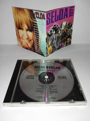 Cd Selda Bağcan Moğollar 1971 Türkülerimiz 1 albümü. Orijinal. Majör dönem baskı albümü. Disk 10 üzerinden 9.5 temiz Sorunsuz çalışıyor koleksiyonluk.  Katip Arzuhalim Yaz Yare Böyle, Adaletin Bu Mu Dünya, Çemberimde Gül Oya, Yalan Dünya, Kalenin Dibinde Taş Ben Olaydım, Tatlı Dillim, Mapushanelere Güneş Doğmuyor, Mapushane İçinde Mermerden Direk, Dane Dane Benleri, Gesi Bağları, Altın Kafes, Bülbül, Bölemedim Felek İle Kozumu, Eyvah Gönül Sana Eyvah, Anayasso, Nem Kaldı, O Günler