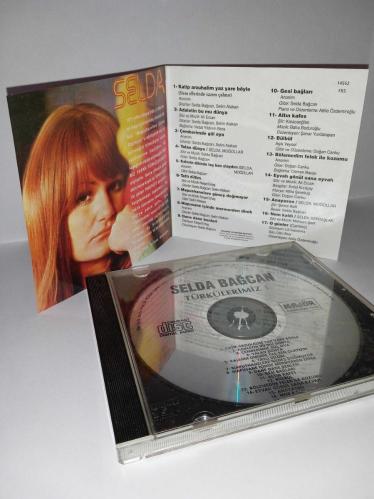 Cd Selda Bağcan Moğollar 1971 Türkülerimiz 1 albümü. Orijinal. Majör dönem baskı albümü. Disk 10 üzerinden 9.5 temiz Sorunsuz çalışıyor koleksiyonluk.  Katip Arzuhalim Yaz Yare Böyle, Adaletin Bu Mu Dünya, Çemberimde Gül Oya, Yalan Dünya, Kalenin Dibinde Taş Ben Olaydım, Tatlı Dillim, Mapushanelere Güneş Doğmuyor, Mapushane İçinde Mermerden Direk, Dane Dane Benleri, Gesi Bağları, Altın Kafes, Bülbül, Bölemedim Felek İle Kozumu, Eyvah Gönül Sana Eyvah, Anayasso, Nem Kaldı, O Günler