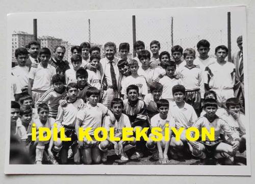 TÜRKİYE CUMHURİYETİ ESKİ SAĞLIK BAKANI YILDIRIM AKTUNA'NIN ORİJİNAL 2'Lİ AJANS-BASIN FOTOĞRAFI SETİ - 18 x 12 cm EBADINDA - YILDIRIM AKTUNA, MERTERSPOR'UN ÇOCUK FUTBOL TAKIMIYLA TOPLUCA HATIRA POZU VERİRKEN ve SAHADA TOP OYNARKEN ÇEKİLMİŞ 2 FARKLI KARE, MAYIS 1991