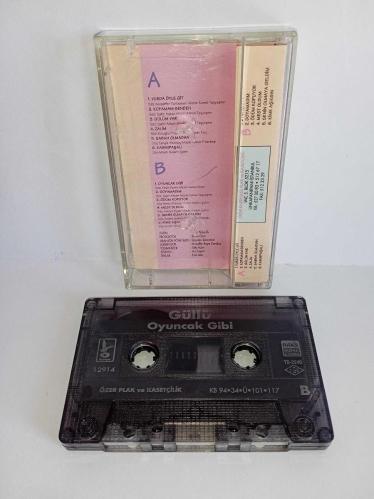 Kaset Güllü oyuncak gibi albümü. Orijinal 1994 baskı kırmızı bandrollü albüm. Kartonetin renginde hafif solma var. Onun dışında eksiksiz ve çok temiz. Kaset sorunsuz çalışıyor