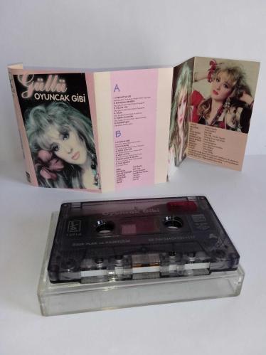 Kaset Güllü oyuncak gibi albümü. Orijinal 1994 baskı kırmızı bandrollü albüm. Kartonetin renginde hafif solma var. Onun dışında eksiksiz ve çok temiz. Kaset sorunsuz çalışıyor