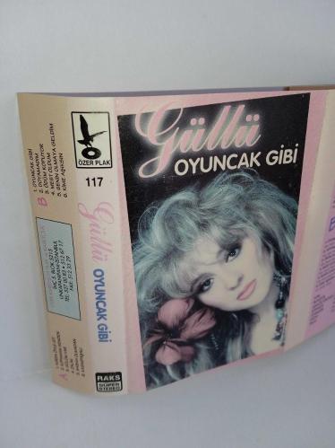 Kaset Güllü oyuncak gibi albümü. Orijinal 1994 baskı kırmızı bandrollü albüm. Kartonetin renginde hafif solma var. Onun dışında eksiksiz ve çok temiz. Kaset sorunsuz çalışıyor