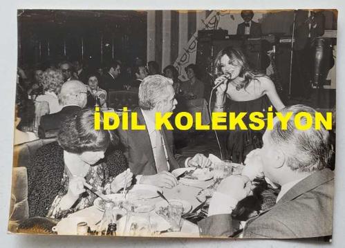 CHP İSTANBUL ESKİ BELEDİYE BAŞKANI ve SHP MİLLETVEKİLİ AYTEKİN KOTİL'İN ORİJİNAL FOTOĞRAFI - 18 x 13 cm EBADINDA - AYTEKİN KOTİL, YEMEK YEDİĞİ MEKANDA MASASINA GELİP ŞARKI OKUYAN SERPİL ÖRÜMCER'İ DİNLERKEN ÇEKİLMİŞ BİR KARE